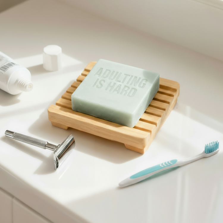 Adulting is Hard soap on bathroom sink with razor and toothbrush.