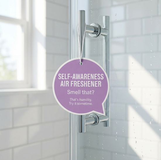 Purple air freshener labeled 'Self-Awareness Air Freshener' on a shower door.